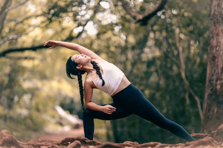 a woman engaging in some body stretching in a natural setting