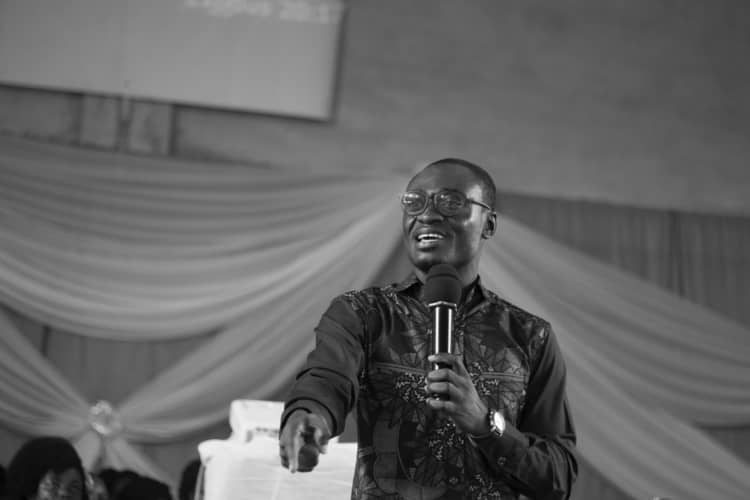 a monochrome photograph of a motivational speaker giving a talk.