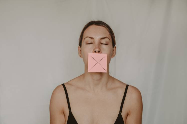 Woman with a post it on her mouth