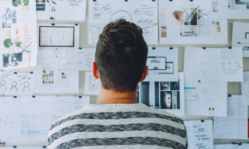 Man looking at his research findings placed on a wall